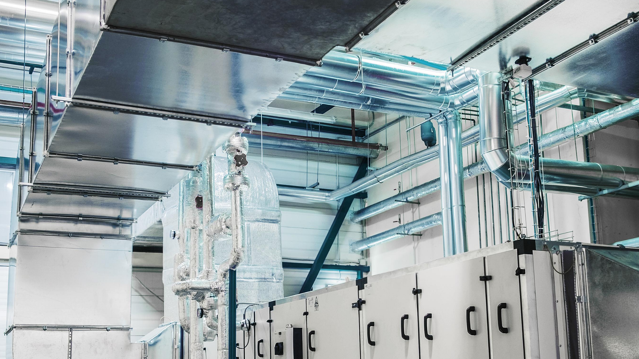 Commercial HVAC system with visible compressor units and ductwork, illustrating the essential components of air conditioning systems for businesses.